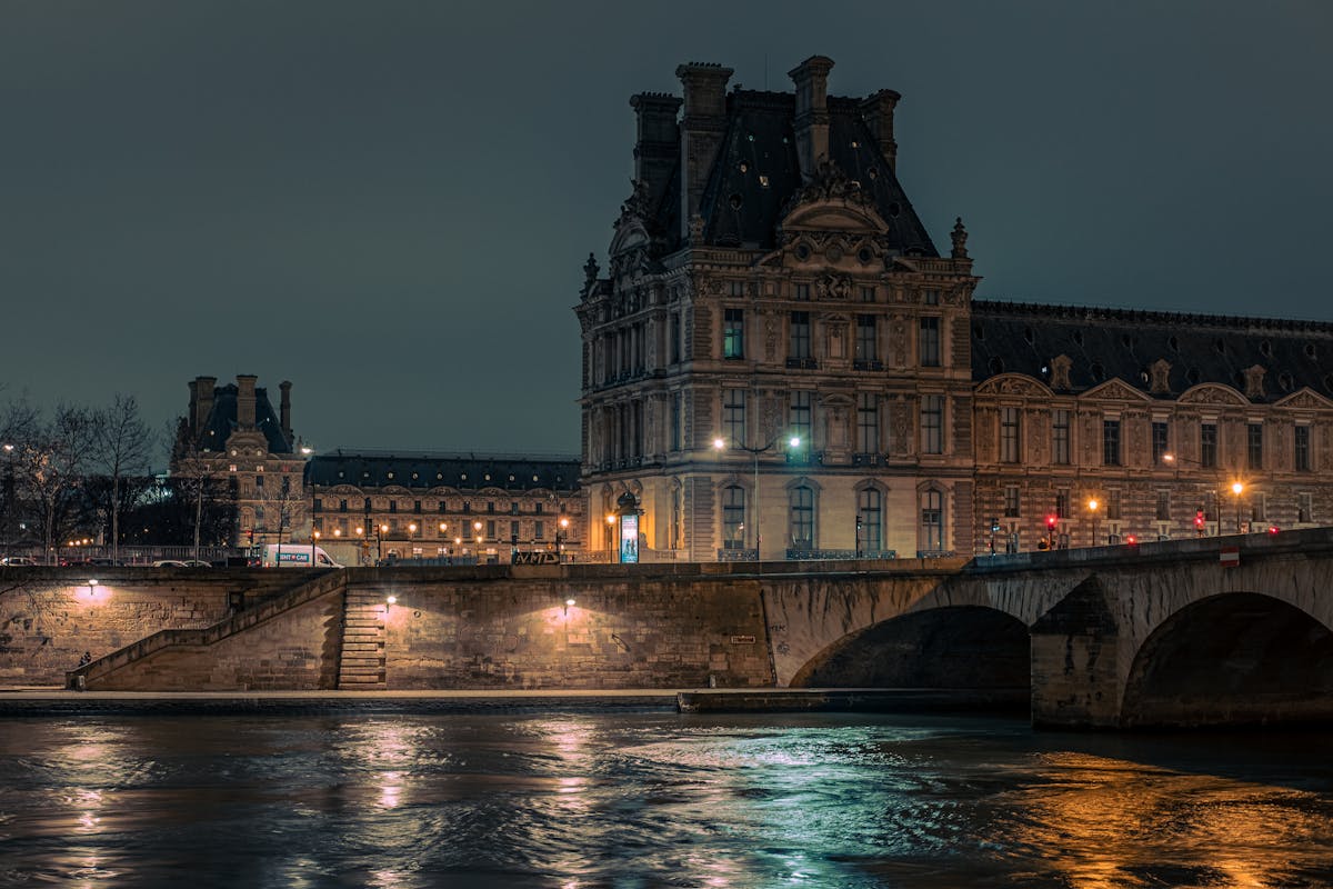 Illuminated Louvre Museum by the Seine in Paris at night