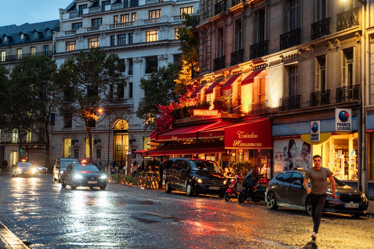 Illuminated Parisian brasserie on a wet street at night
