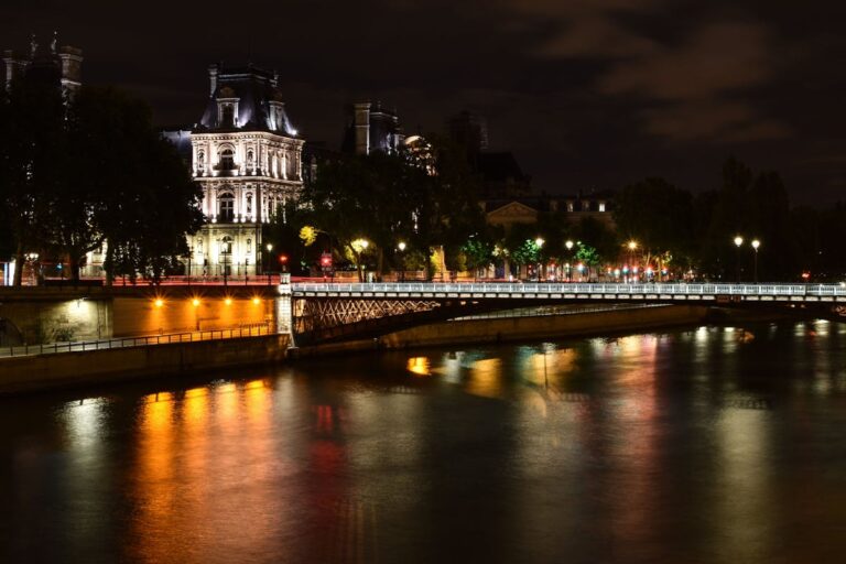 Paris skyline at night with the Eiffel Tower reflecting on the Seine River