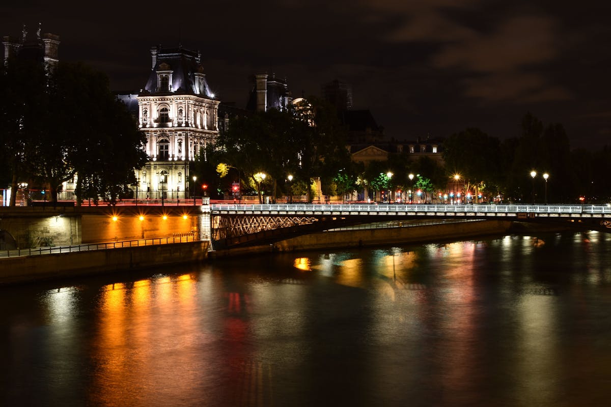 Paris skyline at night with the Eiffel Tower reflecting on the Seine River