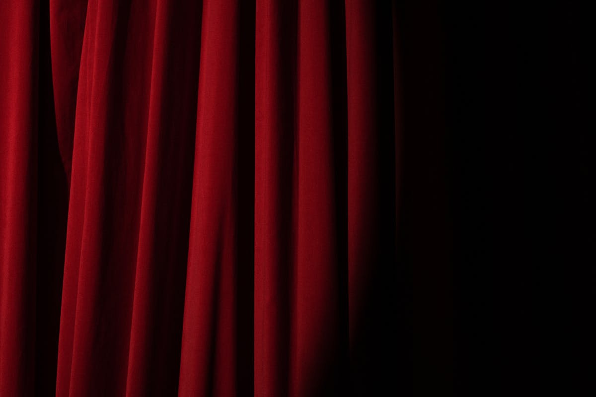 Red velvet theatre curtains with dramatic lighting