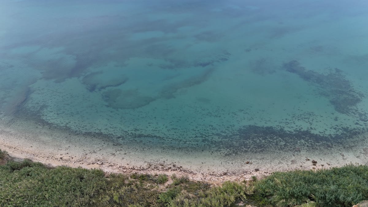 Aerial shot of clear turquoise sea and rocky coastal area in Croatia