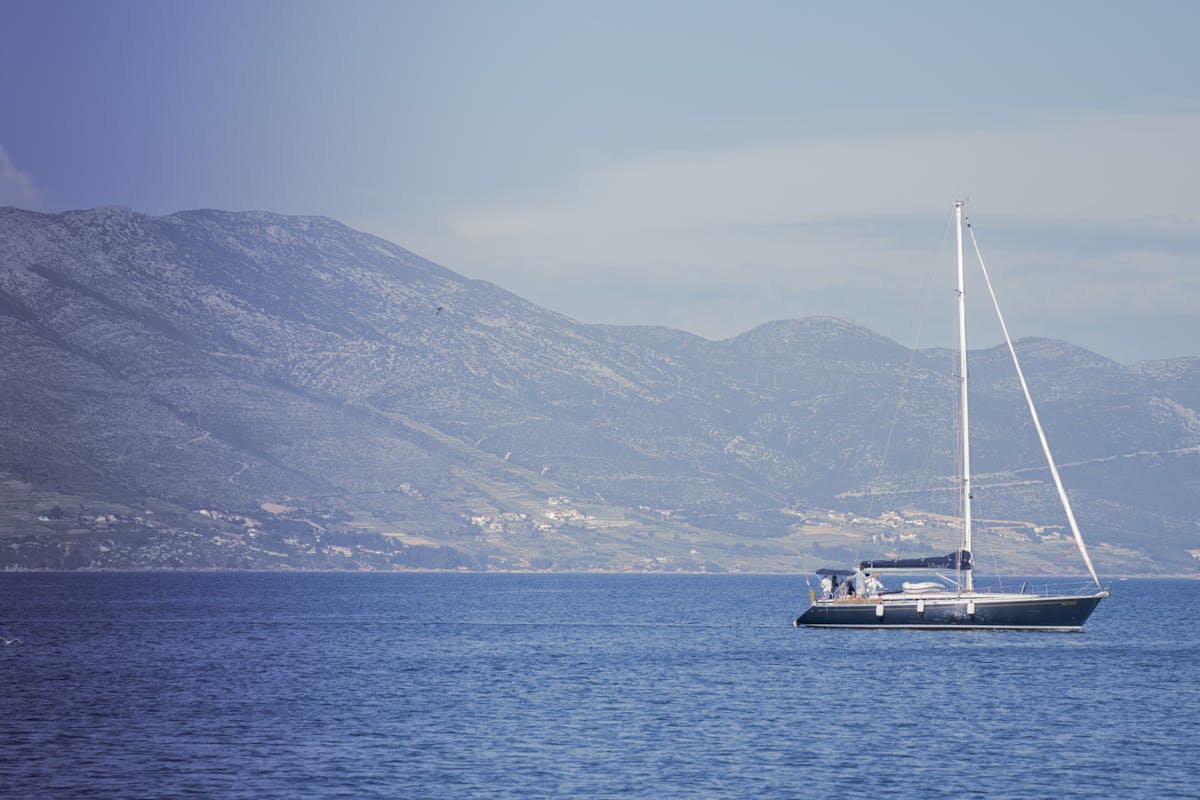 Yacht sailing near Korčula, Croatia with hills in background
