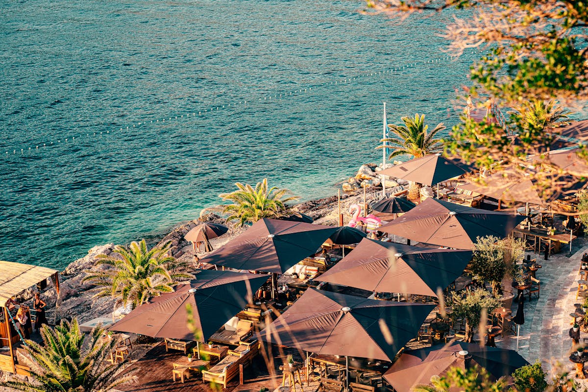Aerial view of beachfront restaurant with umbrellas on the Adriatic Sea in Dubrovnik
