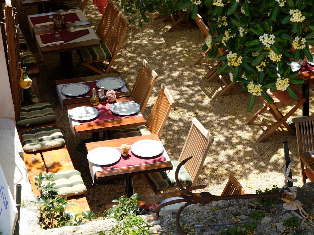 Outdoor dining setup in a Dubrovnik restaurant with stone walls