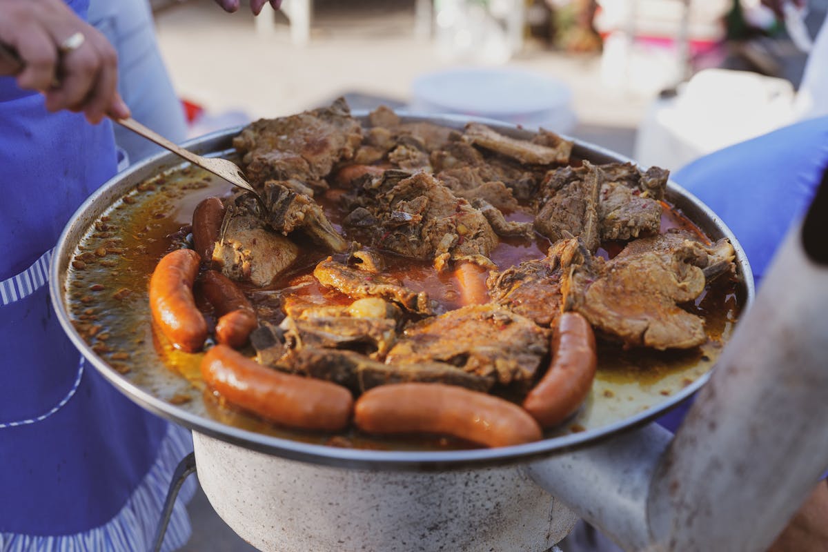 Close-up of sausages and meat grilled outdoors on charcoal