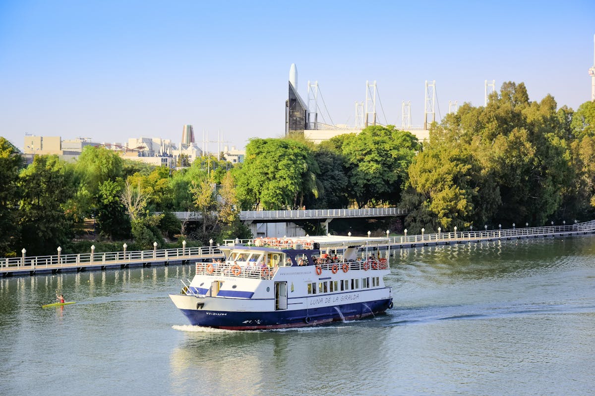 River cruise boat on the Guadalquivir in Seville with buildings along the waterfront