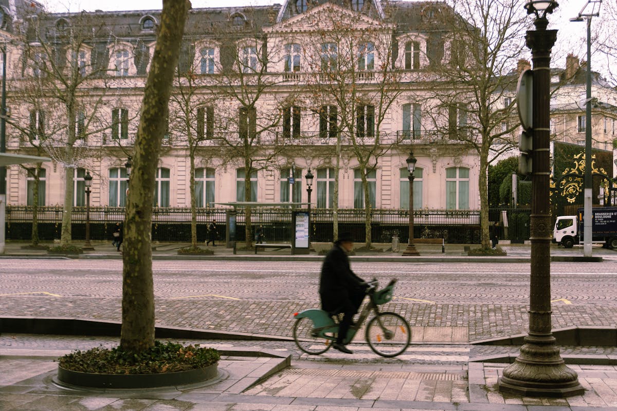 Cyclist riding through a historic street in Paris with classic architecture