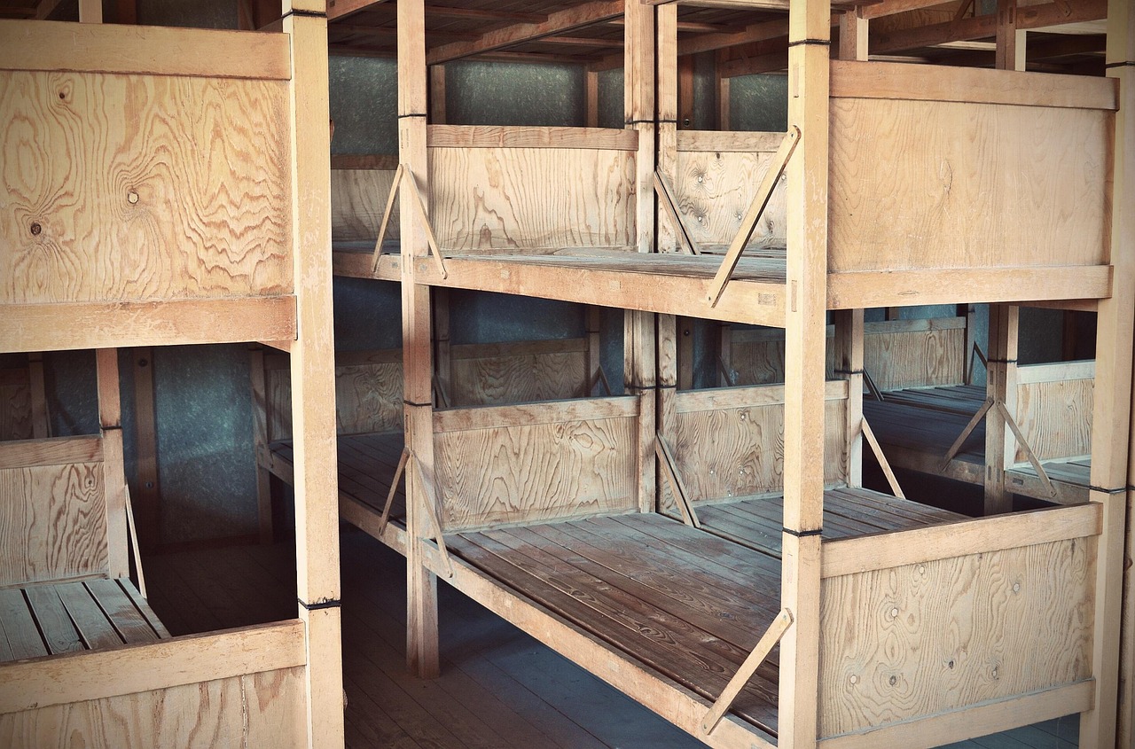 Reconstructed sleeping barracks at Dachau memorial showing cramped wooden bunks
