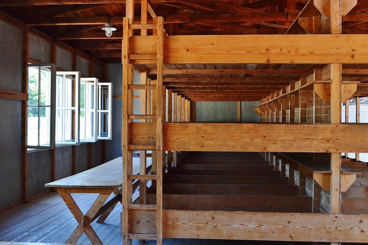 Three-tier wooden bunks inside Dachau concentration camp barracks