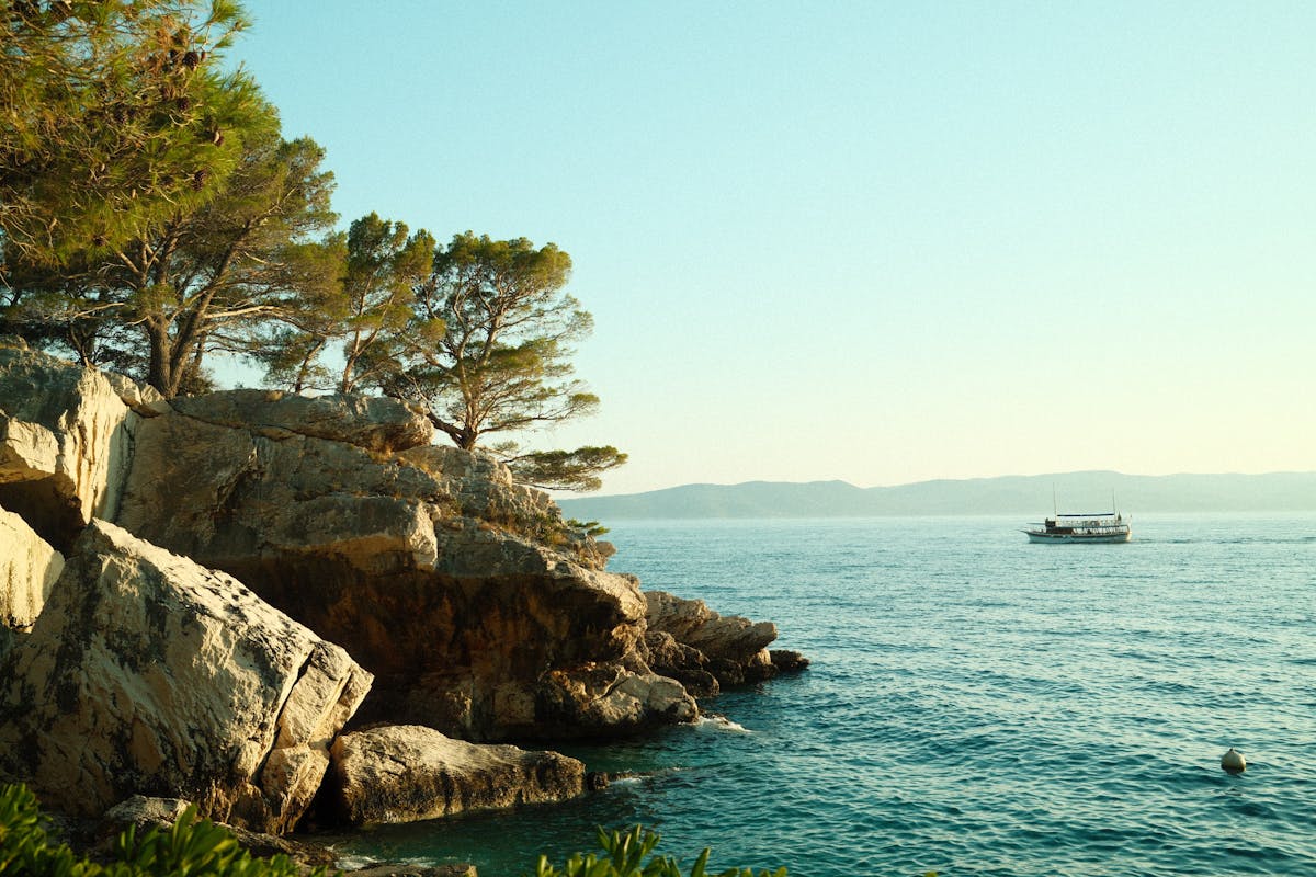 Rocky coastline and boat in Brela, Croatia