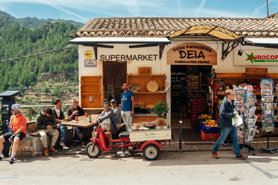 Locals and visitors outside shops in the village of Deia Mallorca