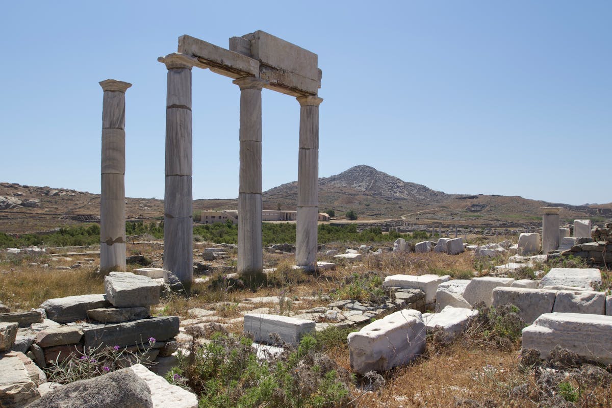 Ancient ruins on the island of Delos with stone foundations stretching across the hillside