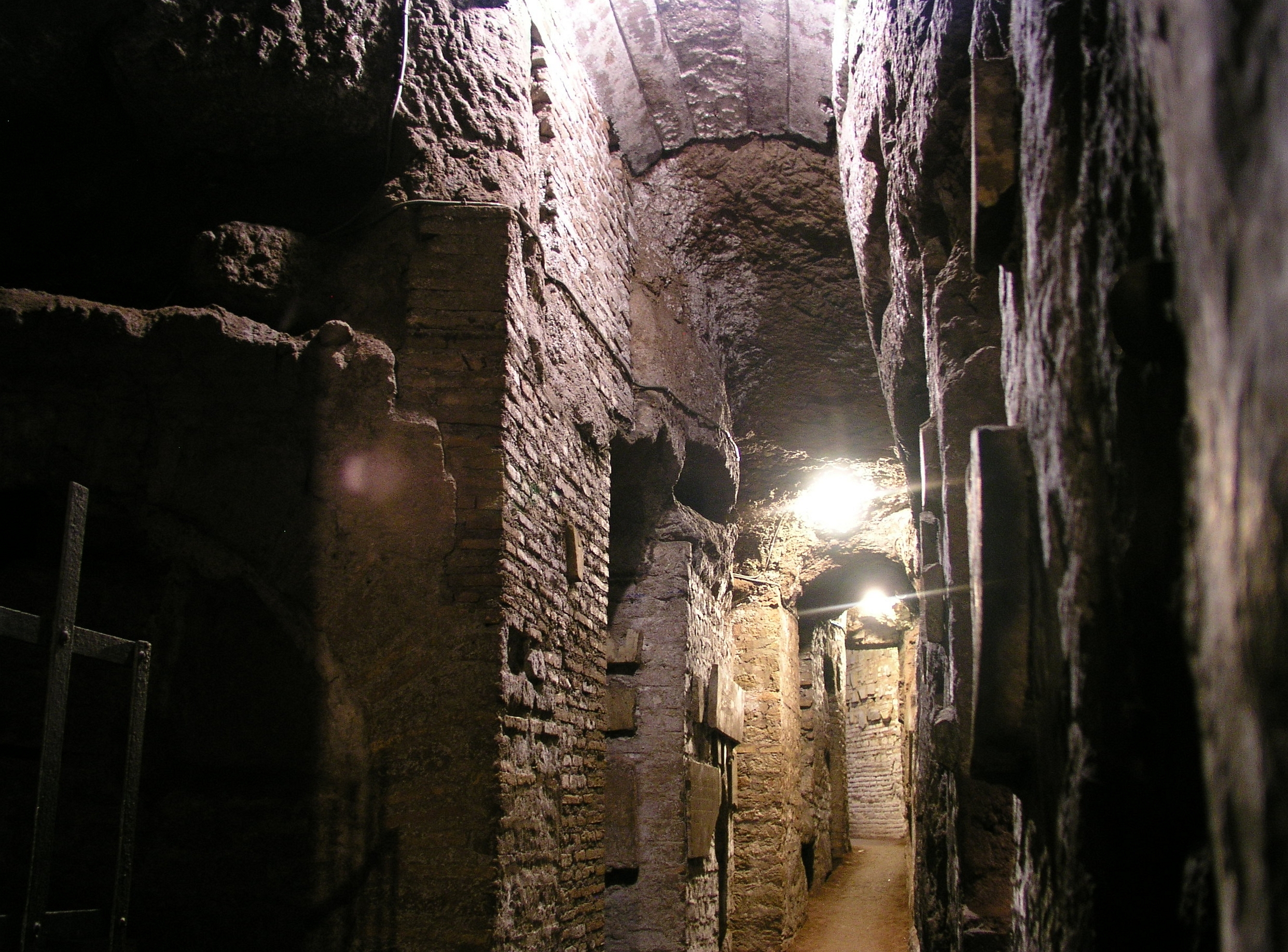 Narrow passage with carved burial niches in the Catacombs of Domitilla in Rome