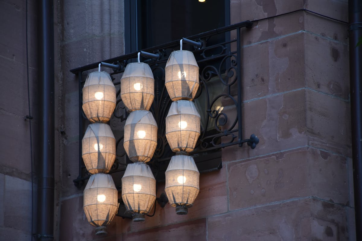 Illuminated hanging lanterns on a German building facade at twilight