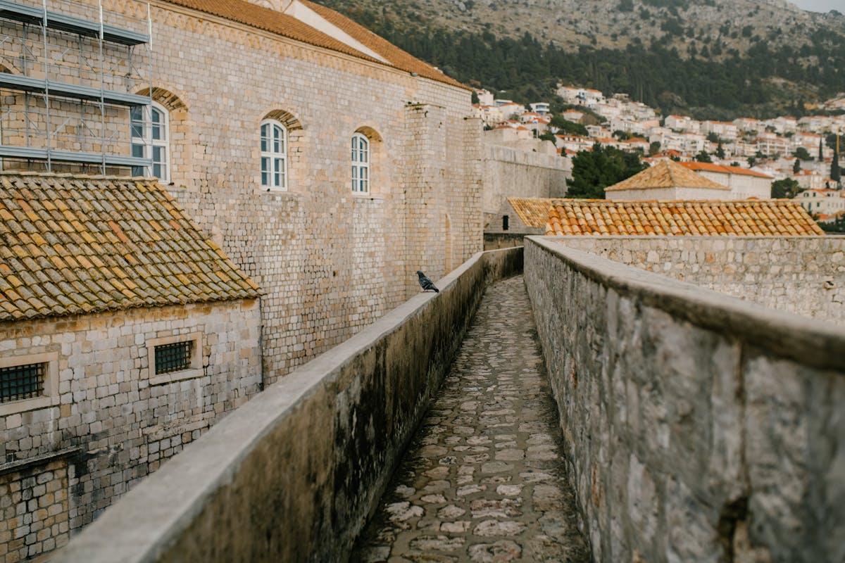 Scenic view of ancient stone walls in Dubrovnik with a narrow cobblestone walkway