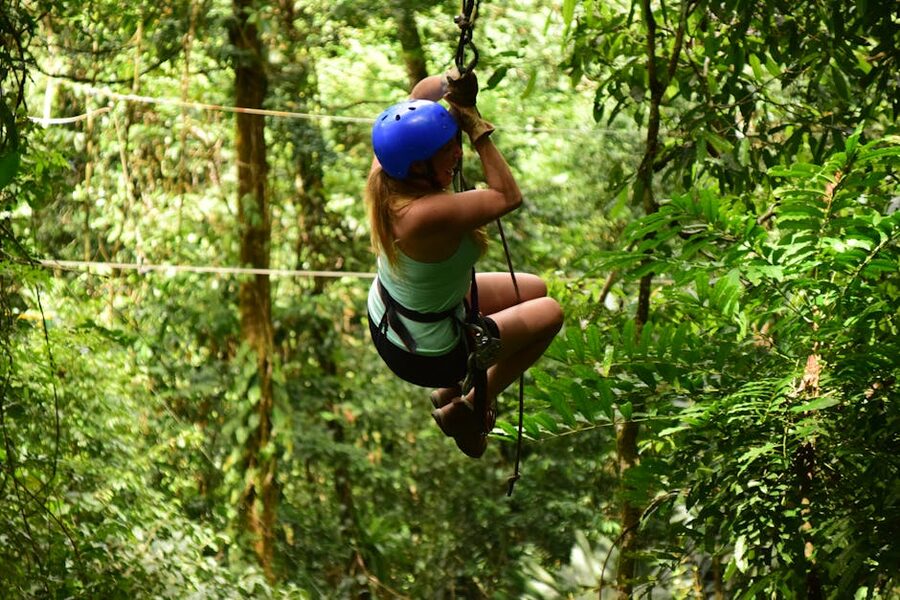 Woman ziplining through forest adventure