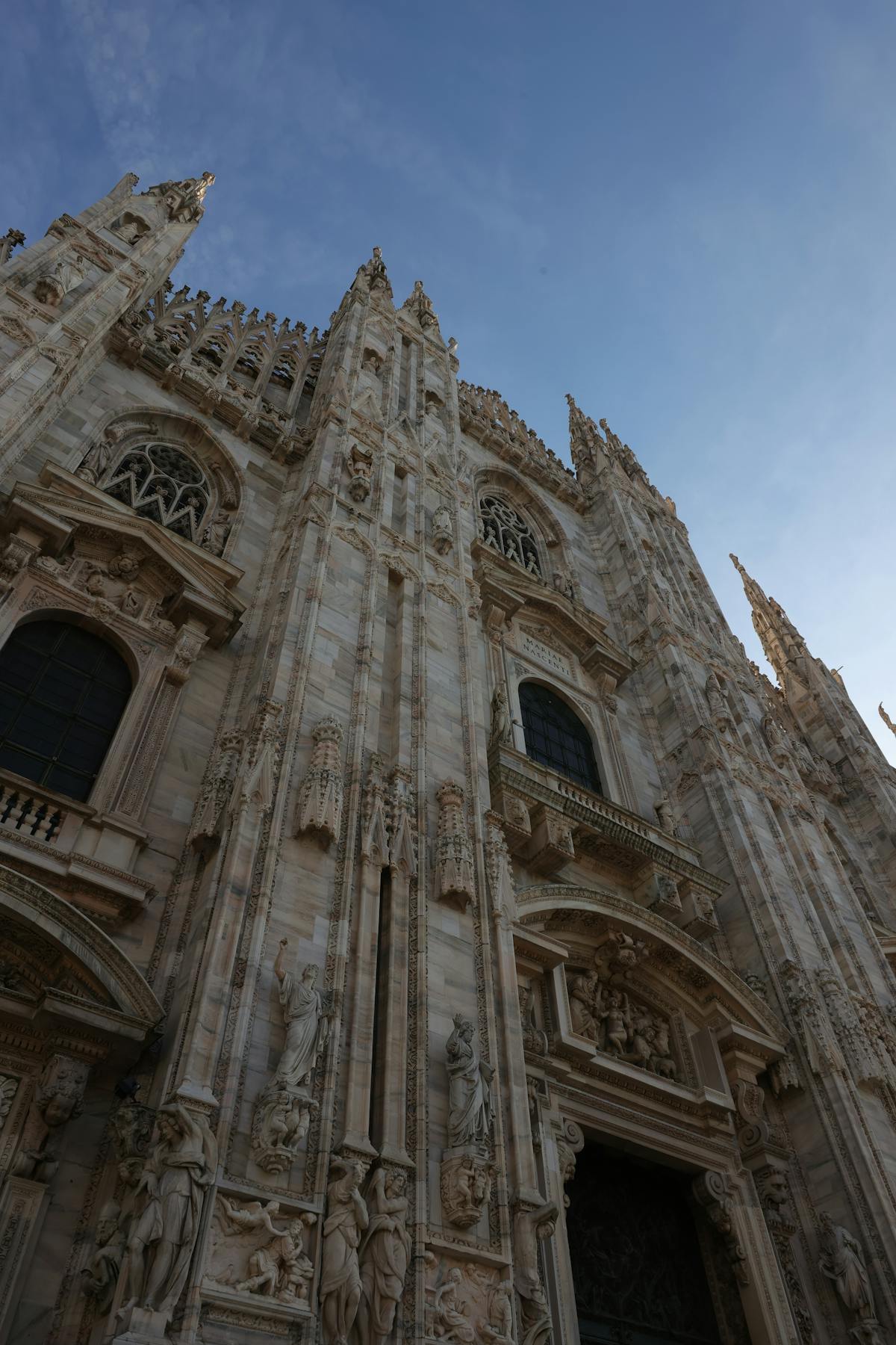 Gothic facade detail of Milan Duomo with spires and statues