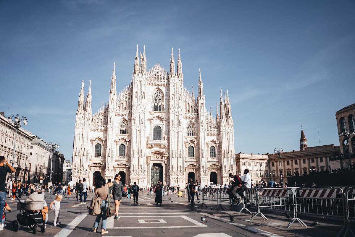 Milan Duomo silhouette against golden sunset sky