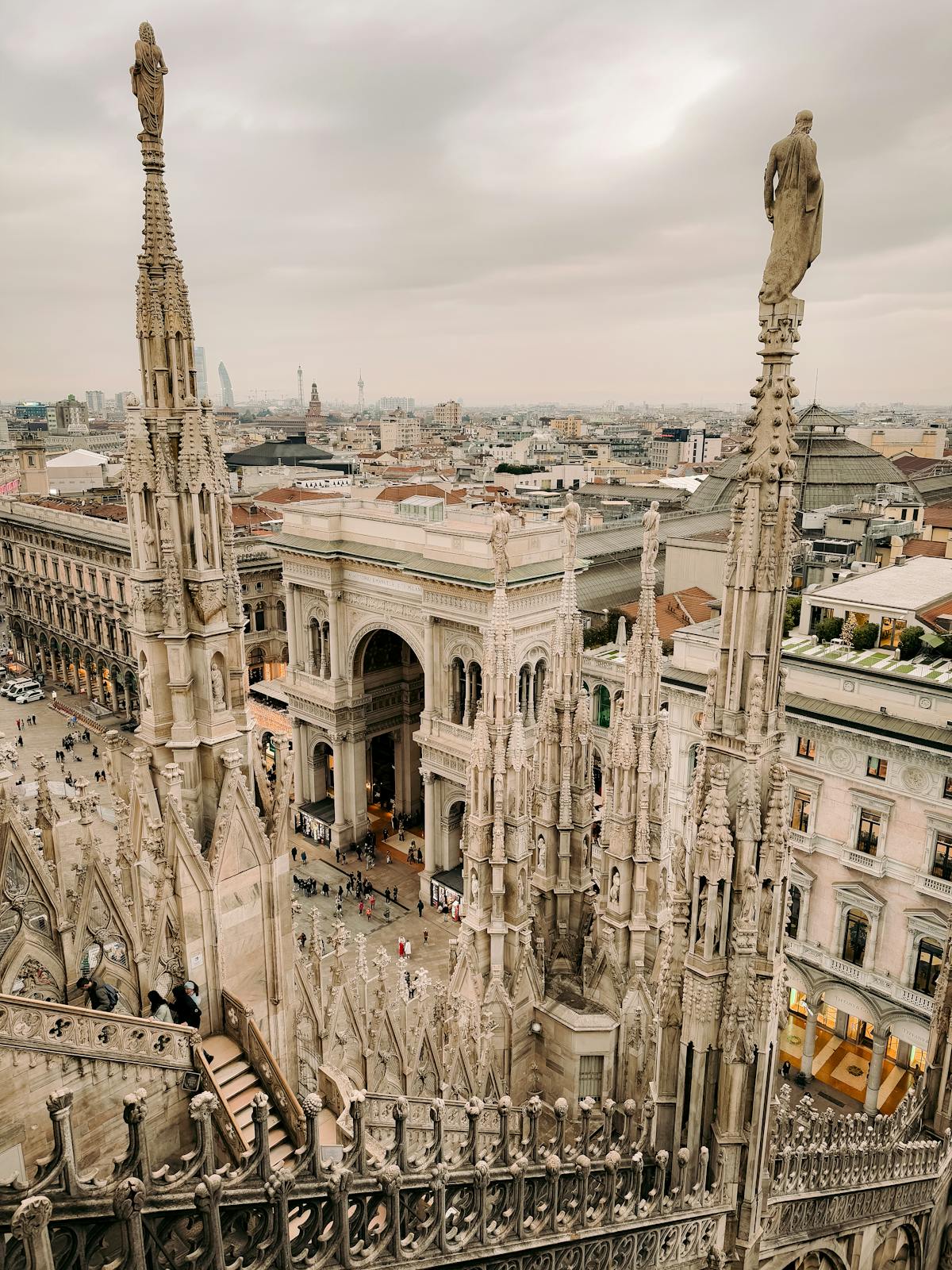Walking along marble terraces of Milan Cathedral among Gothic spires