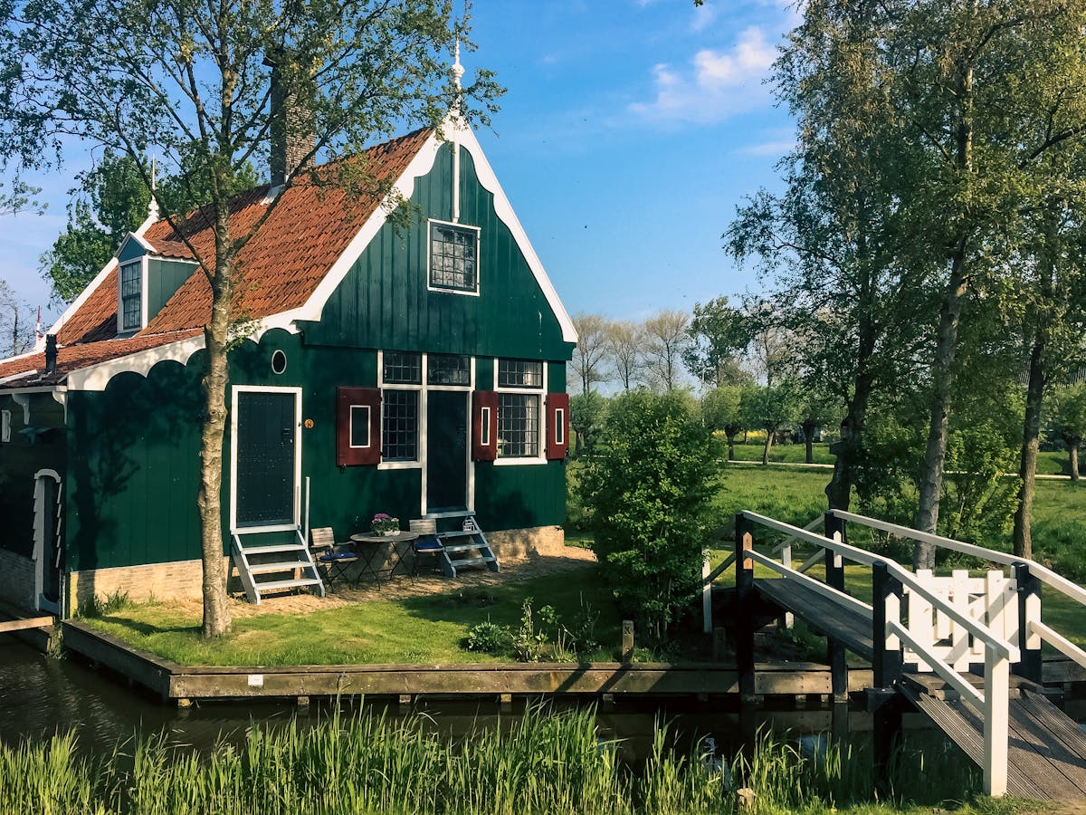 Traditional Dutch cottage with white bridge and garden in Zaandam