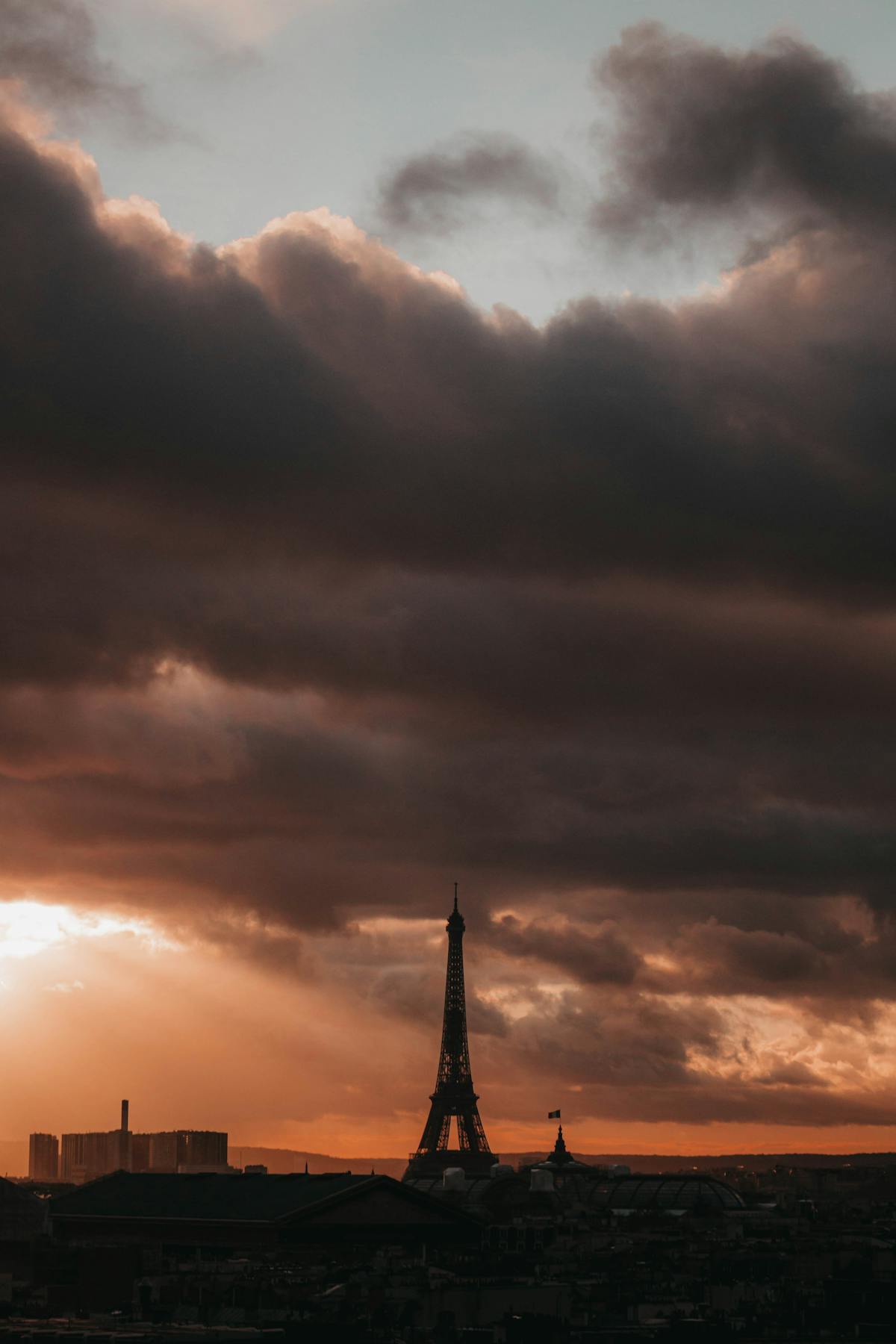 Eiffel Tower against dramatic clouds at sunset in Paris