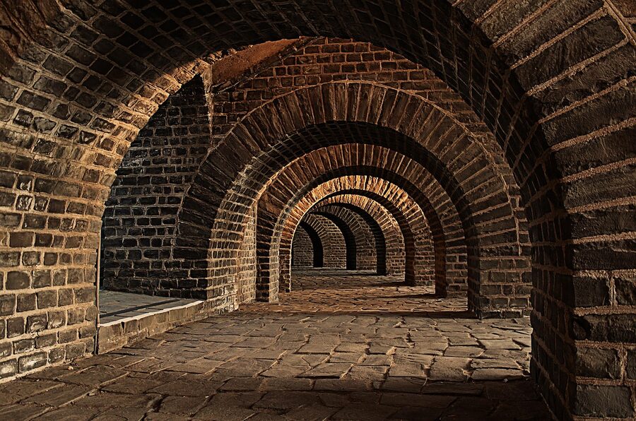 A vaulted stone cellar tunnel with arched ceiling typical of champagne cellars beneath Epernay