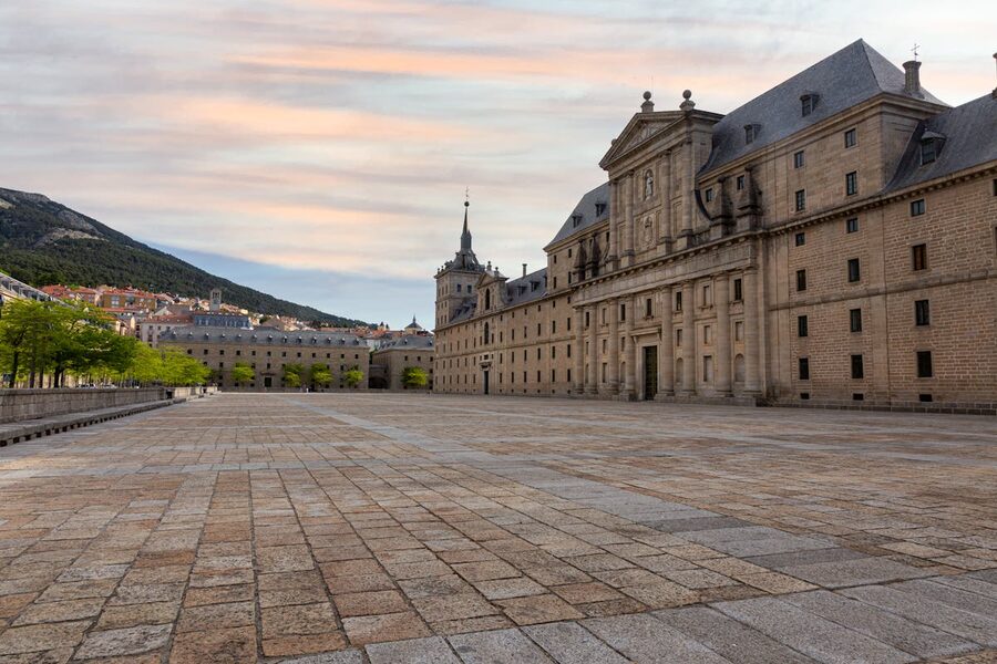 El Escorial monastery at sunset with warm golden light on its granite walls