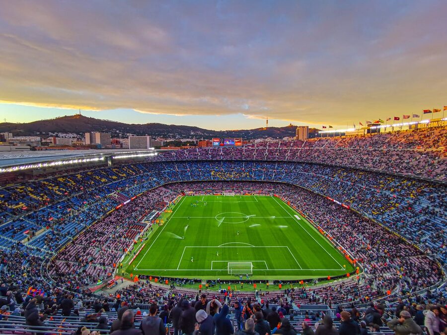 Camp Nou stadium filled with spectators during a football match at sunset