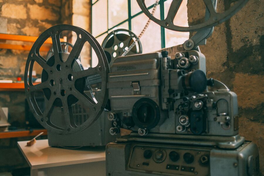 Close-up of a vintage film projector with film reels in a dimly lit projection room