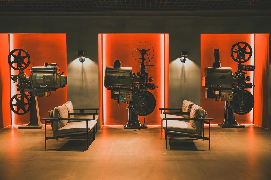 A vintage film projector in a cozy retro cinema room with projection equipment