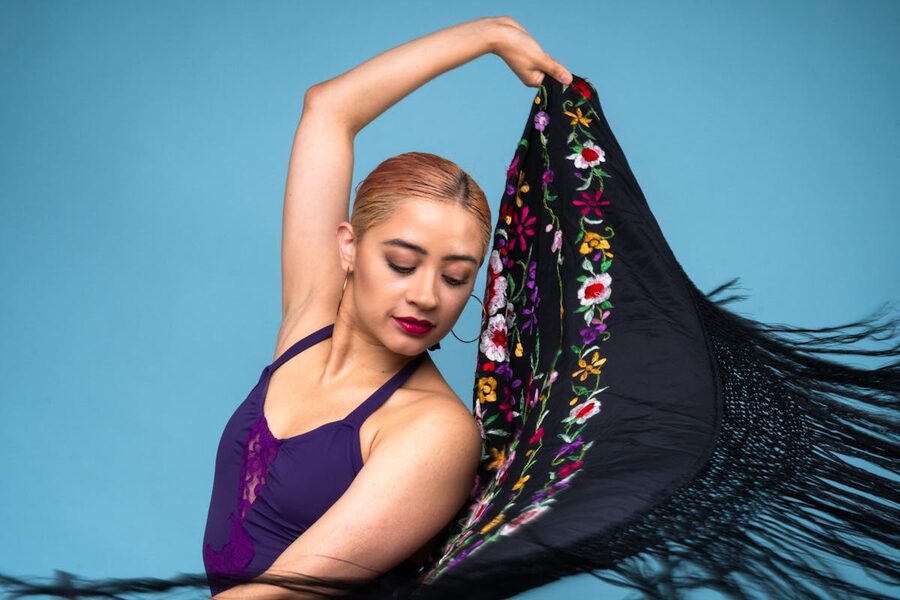 Elegant flamenco dancer poised with colorful shawl performing