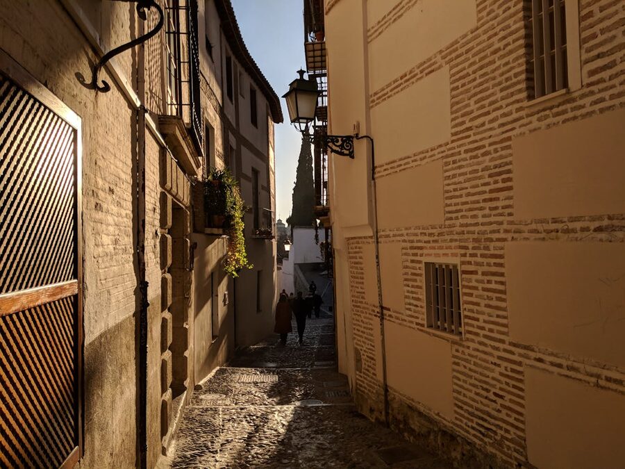 Charming cobblestone alleyway in historic Granada at dusk with warm lighting