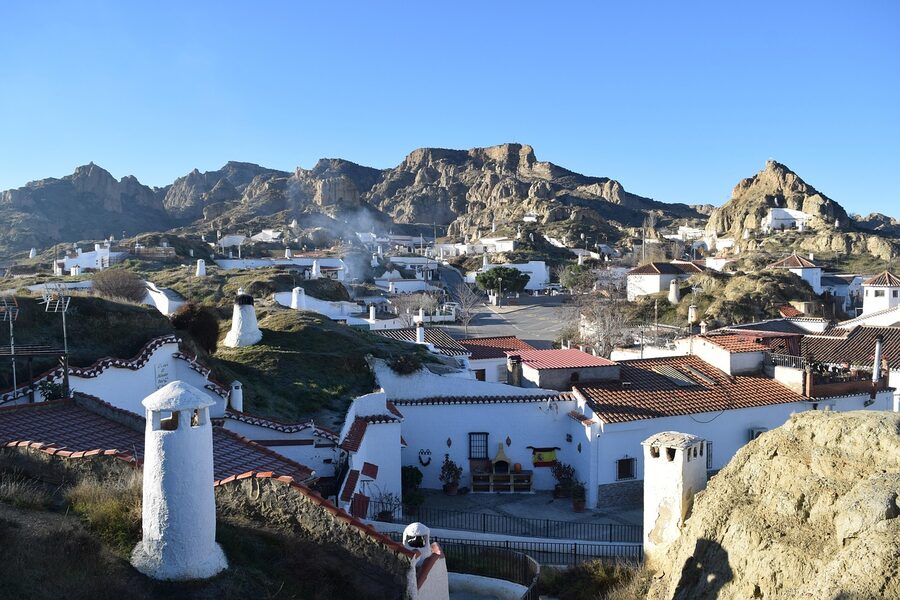 Sunrise over cave dwellings in Guadix near Granada, Spain with whitewashed chimneys emerging from the hillside