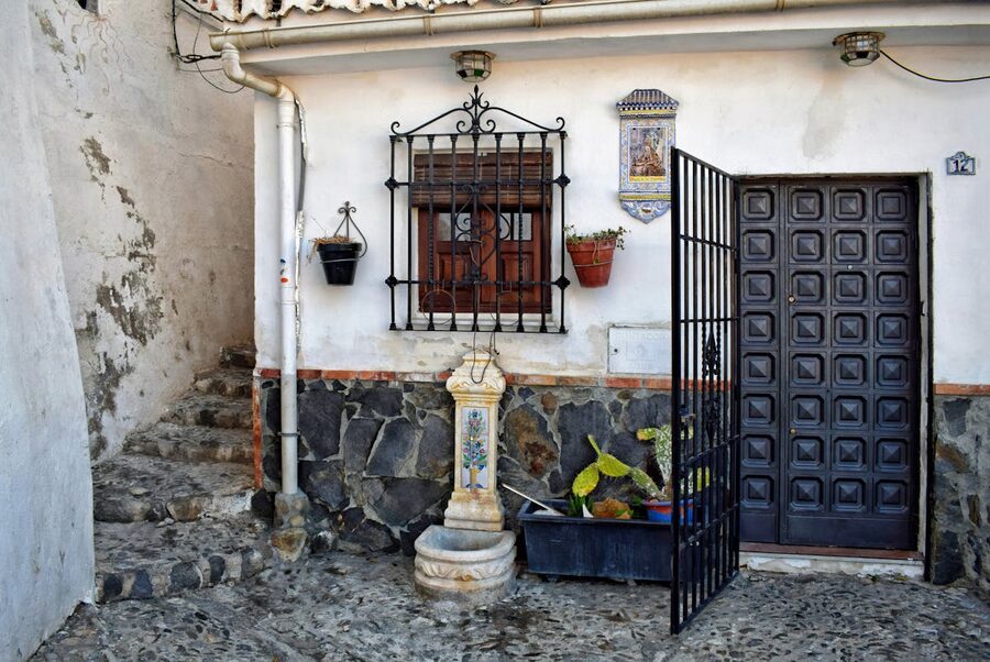 Traditional Spanish courtyard architecture in Granada with iron gate and stone walls