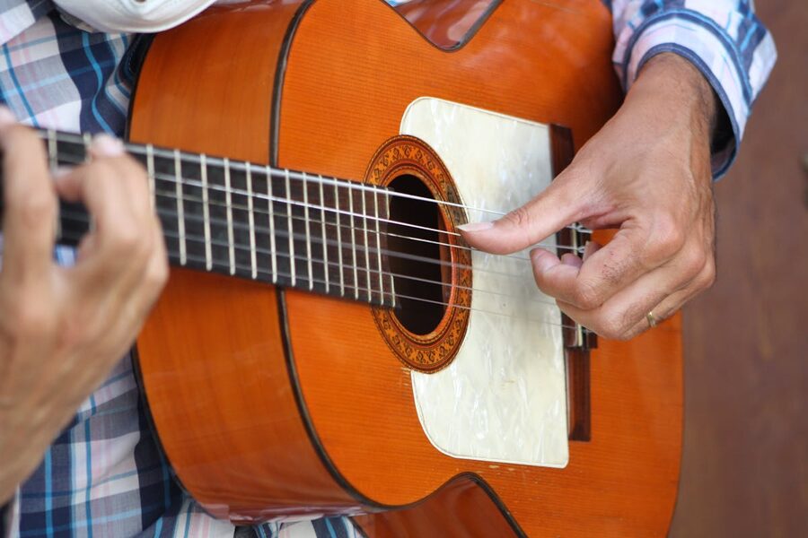 Close-up of a flamenco guitarists hands strumming a wooden guitar