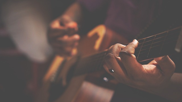 Guitarist hands playing an acoustic flamenco guitar in close-up