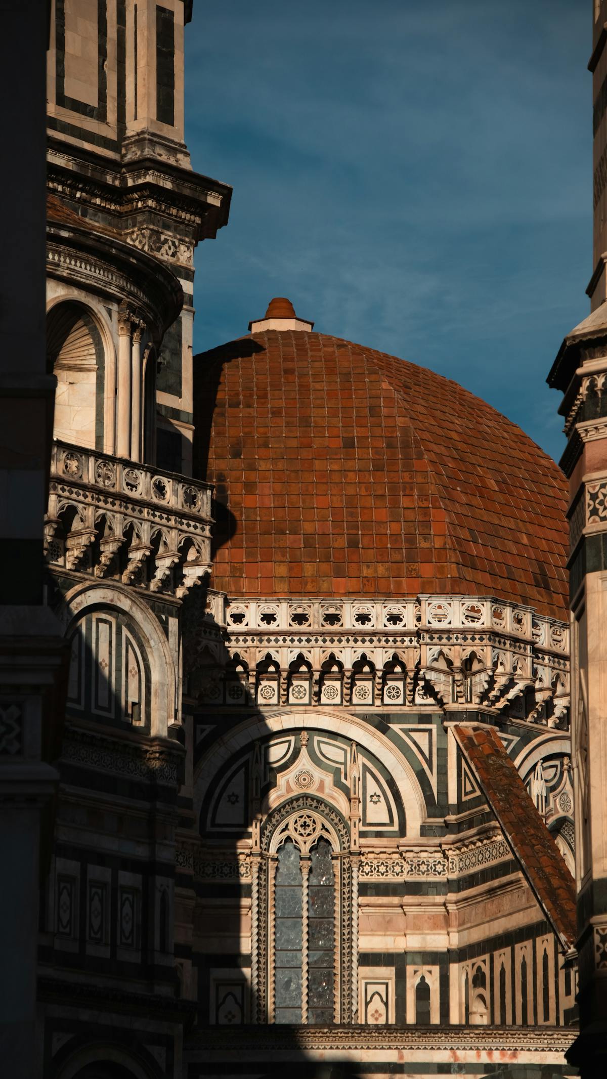Close-up of the Florence Duomo dome at sunset showing terracotta tiles and architectural details