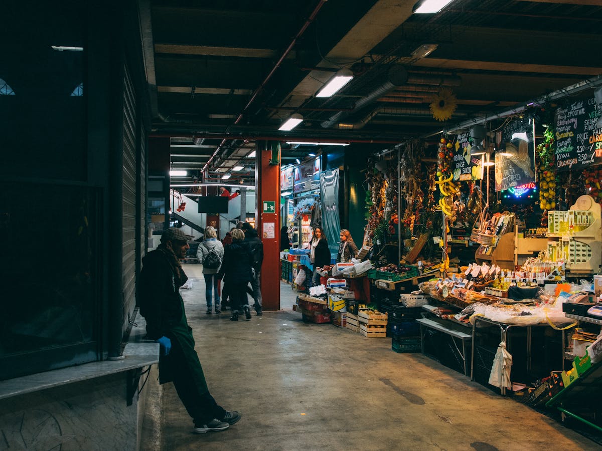 Man standing in a busy indoor market in Florence surrounded by fresh food stalls