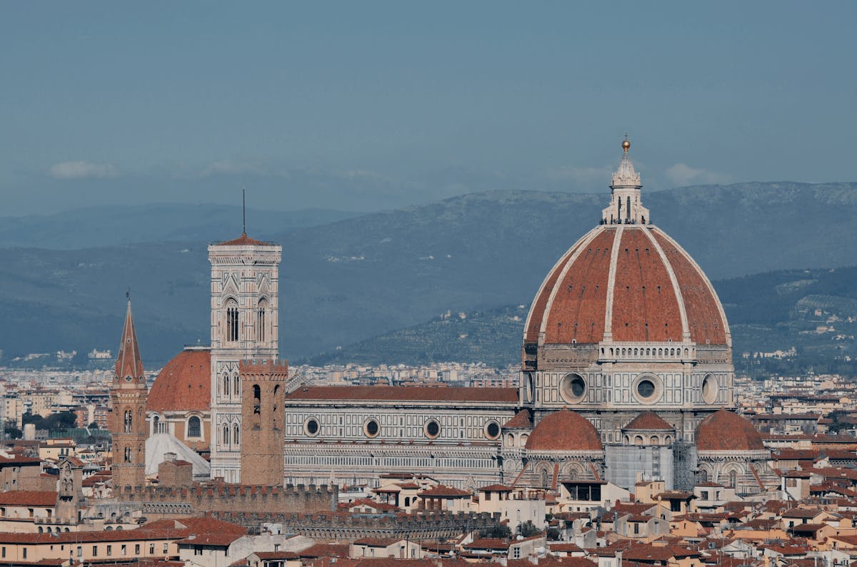 Panoramic view of Florence showing terracotta rooftops with the massive Duomo dome and Giotto bell tower at center