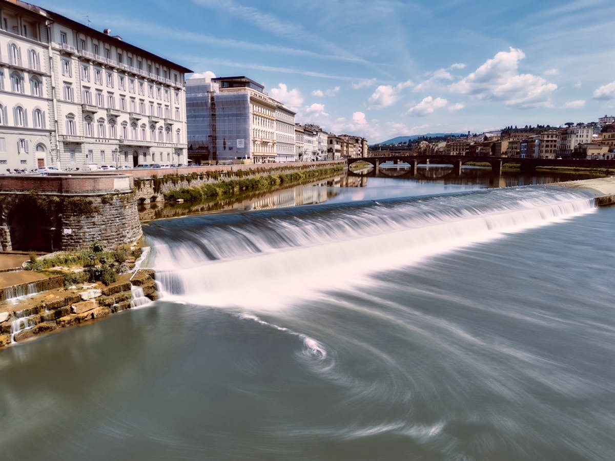 The Arno River and Ponte Vecchio seen from along the riverbank in Florence Italy