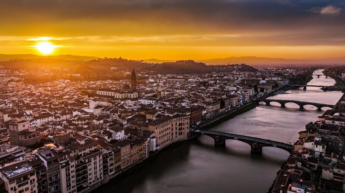 Sunset over Florence and the Ponte Vecchio bridge reflecting on the Arno River