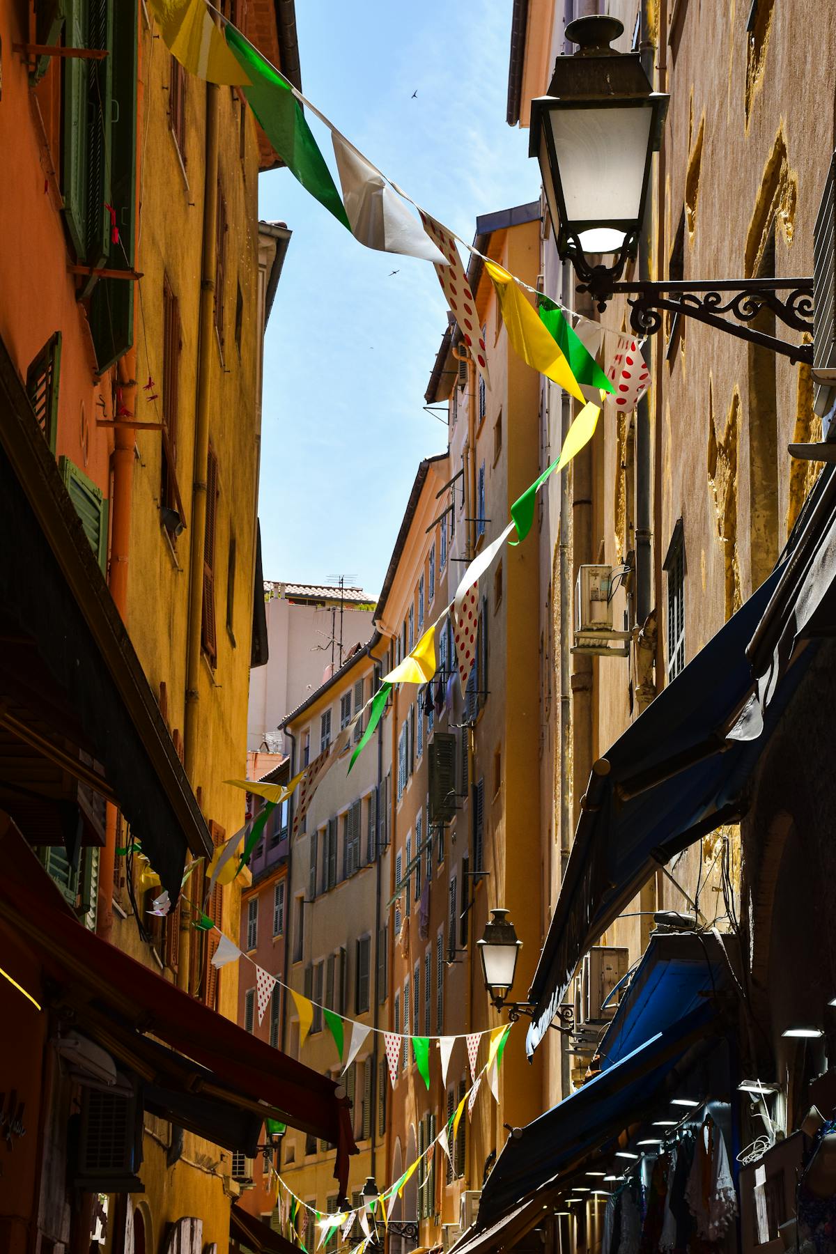 Colourful flags decorating a narrow street in Nice old town France