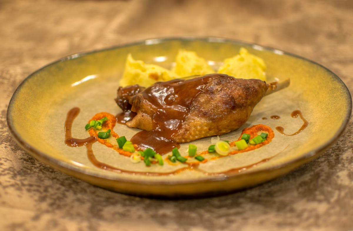Roasted duck leg with sauce and mashed potatoes, a classic Toulouse specialty