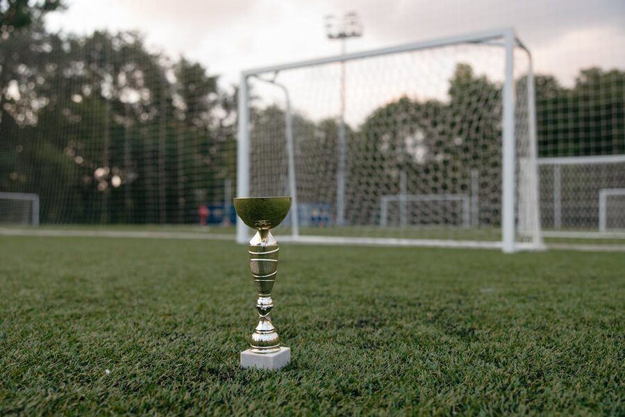 Golden trophy placed on green grass at a football field