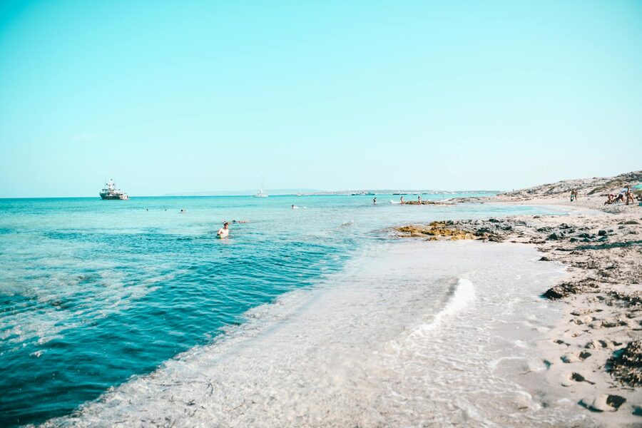 Sandy beach in Formentera Spain with clear blue Mediterranean waters and calm horizon