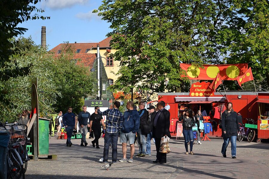 View inside Freetown Christiania Copenhagen showing painted buildings and trees