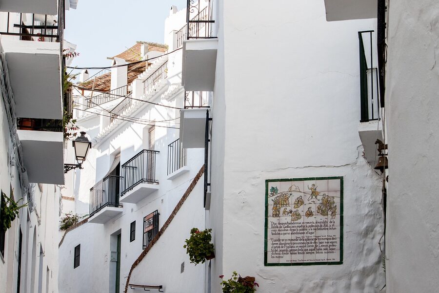 Close view of a traditional whitewashed house with decorative details on a cobblestone street in Frigiliana