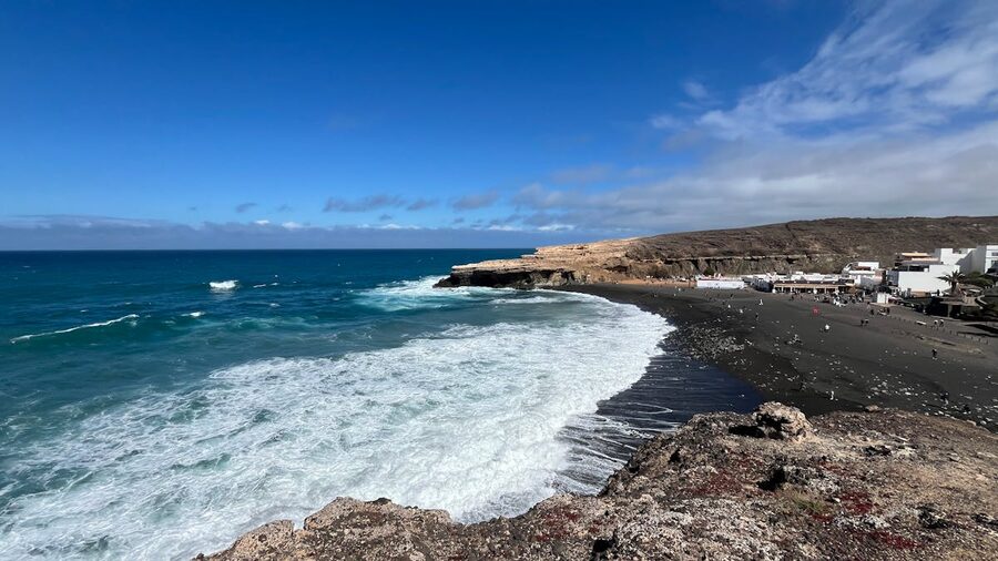 Waves crashing on Ajuy Beach with rocky cliffs in Fuerteventura