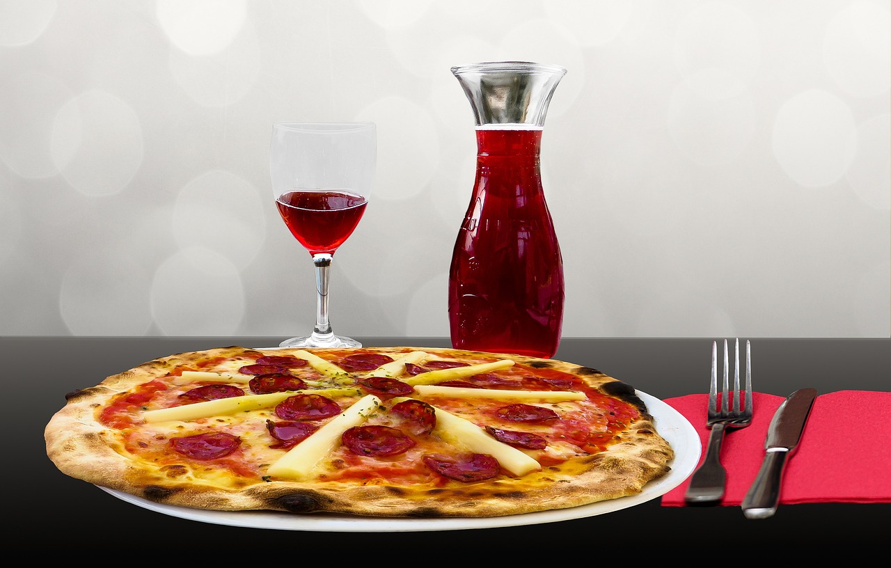 A pizza and glass of red wine served at an Italian restaurant table